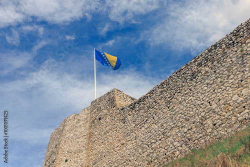 flag of Bosnia and Herzegovina flying on the wall of an old fortress photo