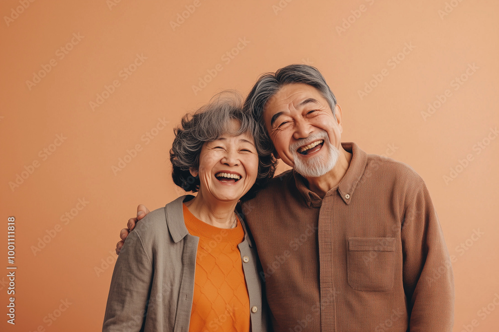An old Asian couple dressed in casual everyday wear, caught in a moment of shared laughter happy lovebird on the solid background
