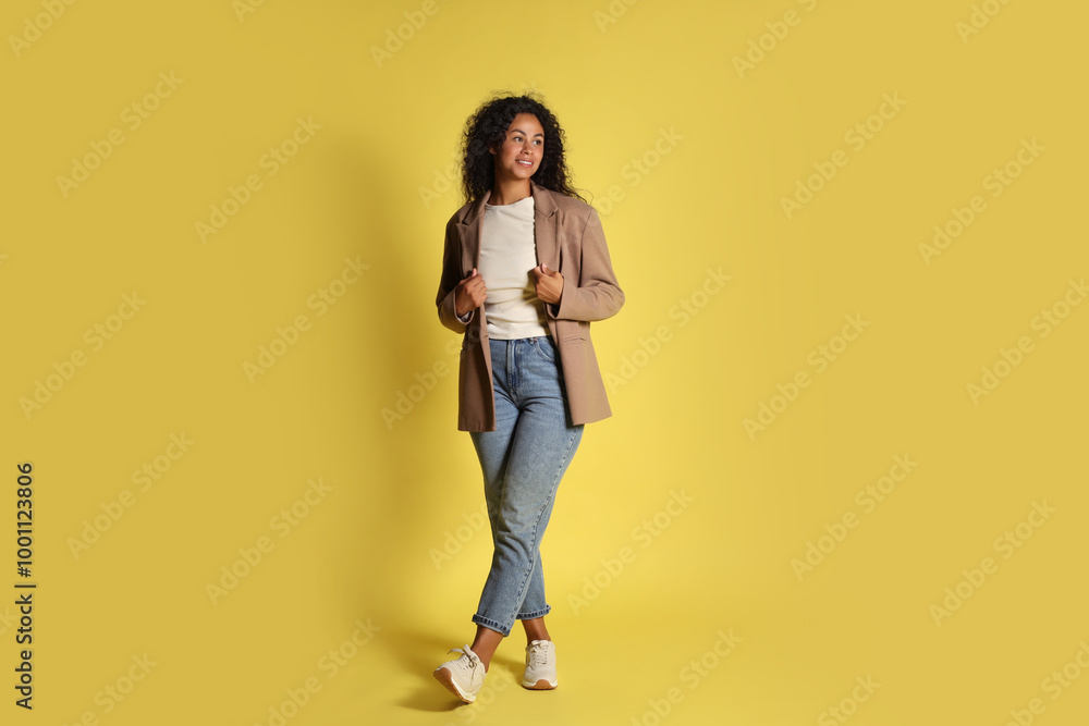 Beautiful woman in stylish jacket on yellow background Beautiful woman in stylish jacket on yellow background