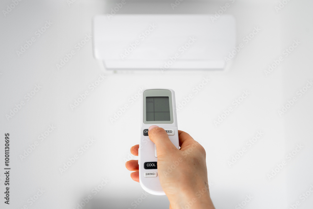 Human hand holding air conditioner remote control Human hand holding air conditioner remote control