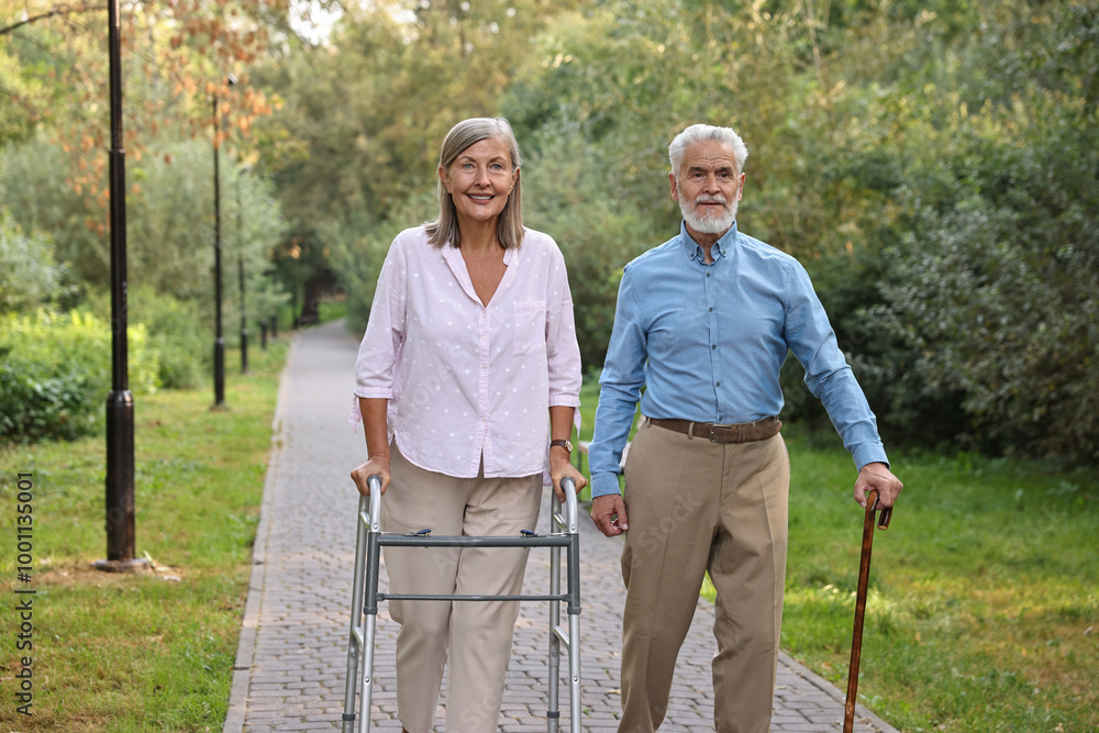 Senior couple with walking frame and cane in park Senior couple with walking frame and cane in park