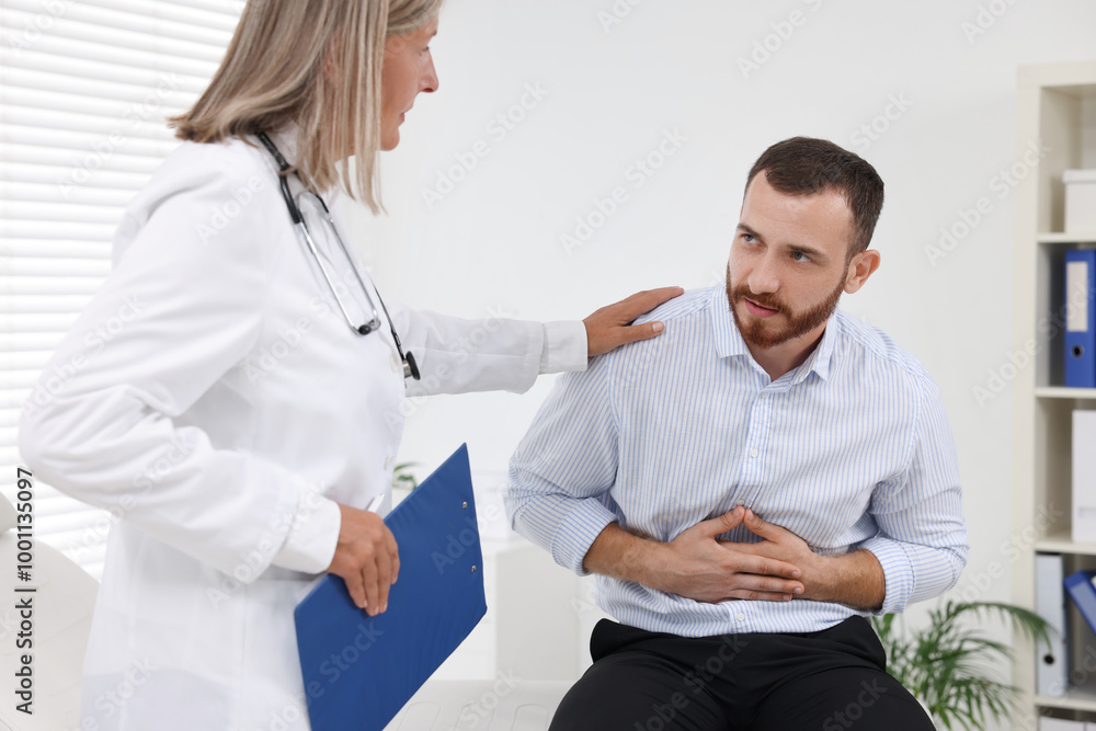 Doctor consulting patient with stomach pain in clinic Doctor consulting patient with stomach pain in clinic
