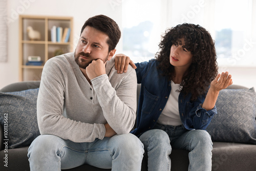 Emotional couple having quarrel on sofa at home. Relationship problems