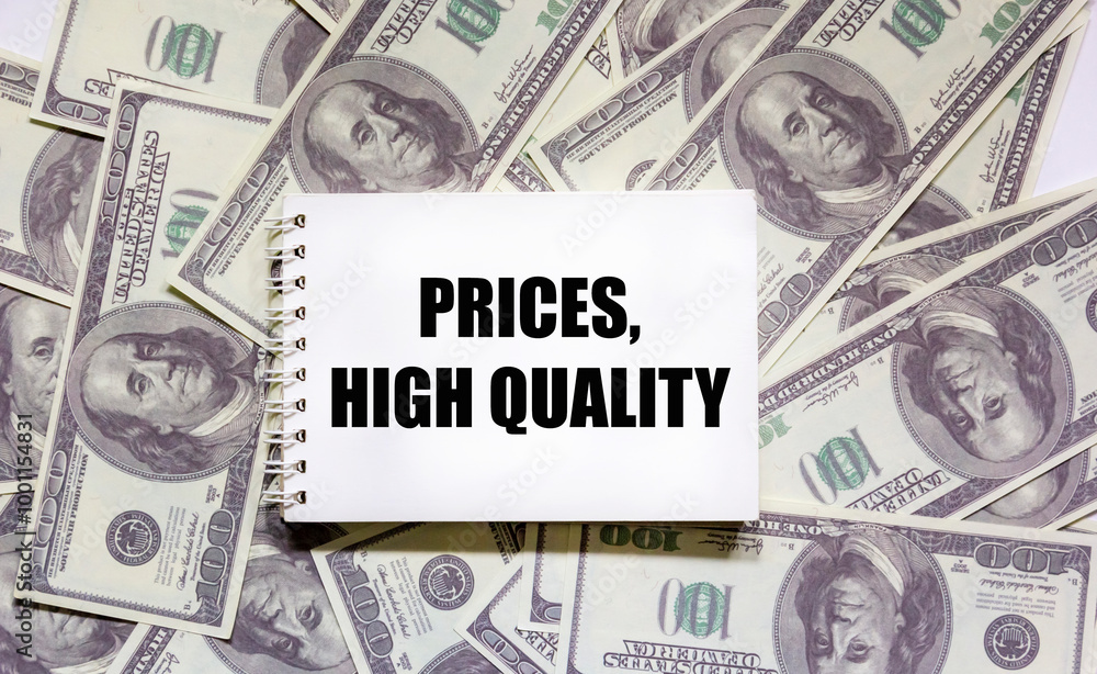 On a notepad the text prices, high quality, Dollars lie on a white background, Financial concept, Quality, service, customer satisfaction On a notepad the text prices, high quality, Dollars lie on a white background, Financial concept, Quality, service, customer satisfaction