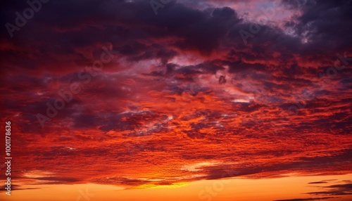 A vivid red sunset paints the evening sky with drama, its fiery hues mingling with billowing clouds. This fantastical backdrop offers space for creative design