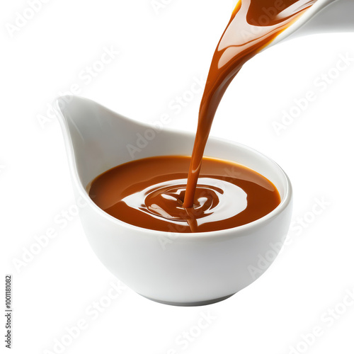 Rich caramel sauce pouring into a white dish photo