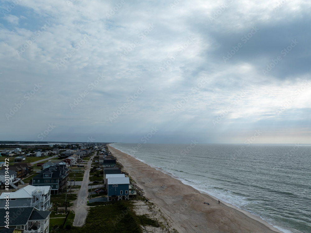 Aerial photo above the shore. Sunrays come through a cloudy sky. Aerial photo above the shore. Sunrays come through a cloudy sky.