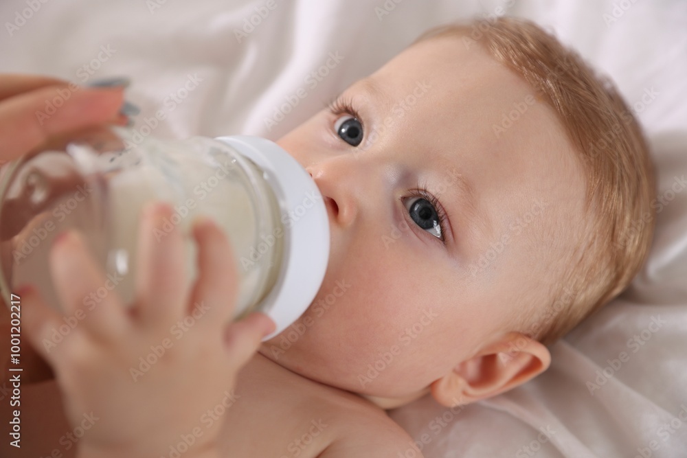 Cute little baby with bottle of milk on bed Cute little baby with bottle of milk on bed