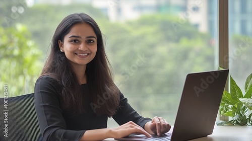 indian businesswoman working on laptop in a modern office | Cheerful woman employee in office | Indian woman employee