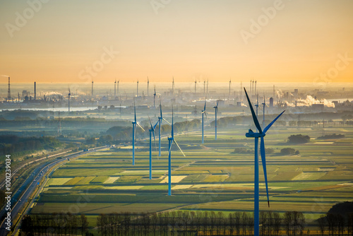 Aerial View on Waasland rural area mixed with wind turbines and harbor of Antwerp in the background during sunrise