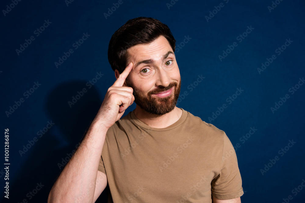 Photo of clever man with stylish beard dressed beige t-shirt hold finger on forehead have idea isolated on dark blue color background Photo of clever man with stylish beard dressed beige t-shirt hold finger on forehead have idea isolated on dark blue color background