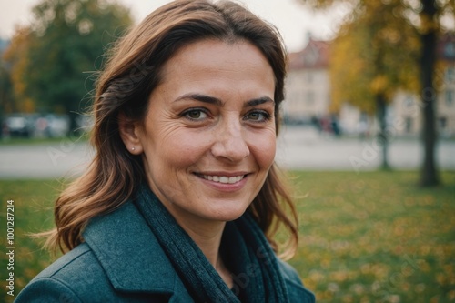 Close portrait of a smiling 40s Romanian woman looking at the camera, Romanian outdoors blurred background photo