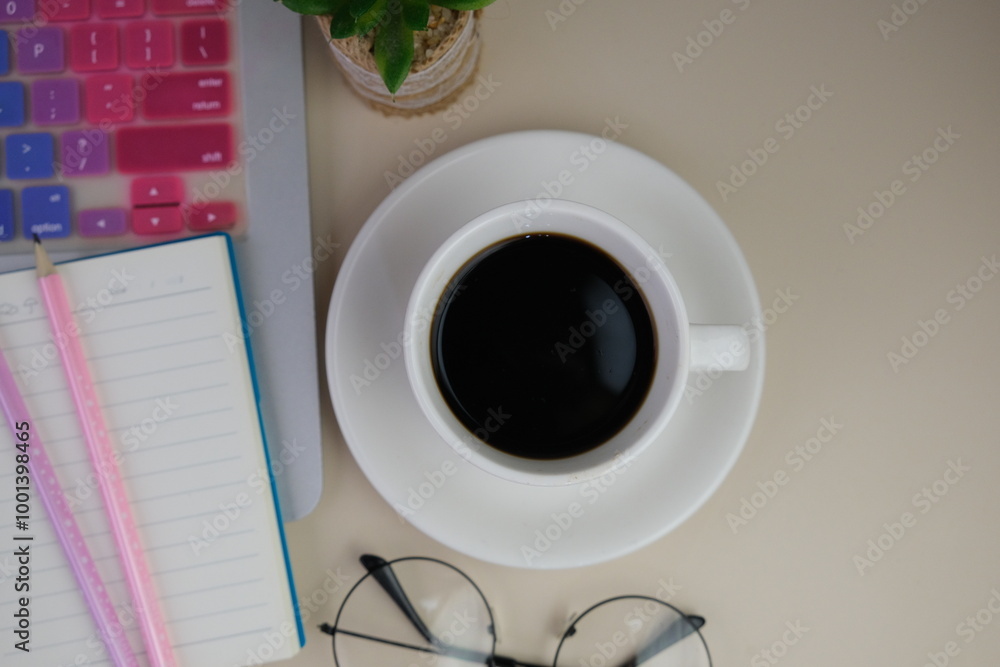 Flatlay of coffee with pink office tools, pink headphone, notebook, pen and a bouquet of pink tulips on pink background as copy space concept Flatlay of coffee with pink office tools, pink headphone, notebook, pen and a bouquet of pink tulips on pink background as copy space concept