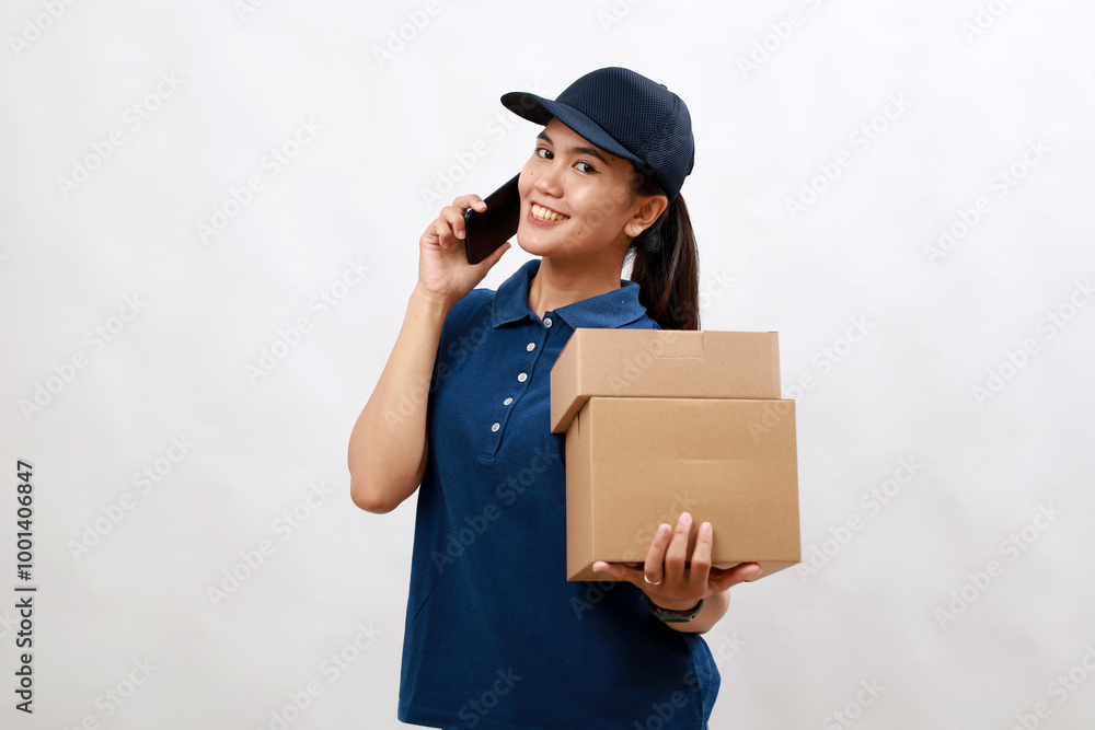 Young delivery asian girl courier over isolated white background holding cardboard box package.Talking use cell phone Young delivery asian girl courier over isolated white background holding cardboard box package.Talking use cell phone