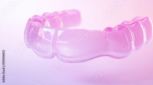 A pink dental appliance is shown in a close up