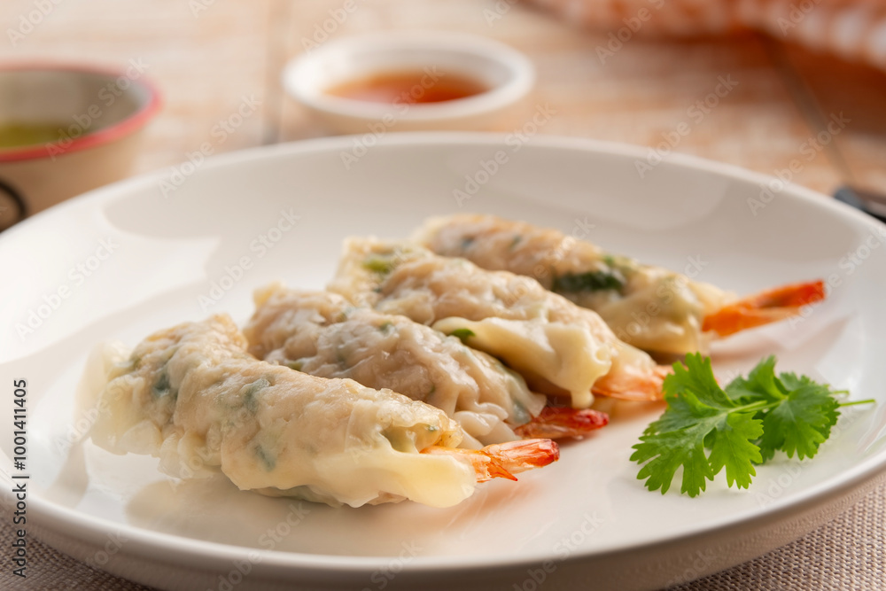 Thai boiled Wonton wrapped with shrimp and minced pork in white plate.appetizer food Thai boiled Wonton wrapped with shrimp and minced pork in white plate.appetizer food
