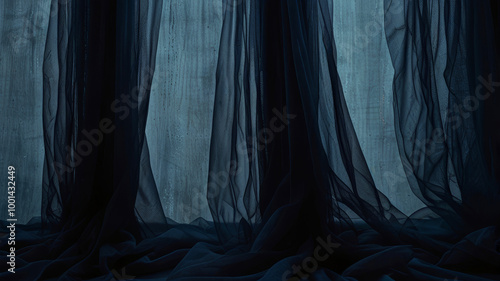 Light airy dark deep blue curtains made of organza or tulle with beautiful folds on the light as a background for design