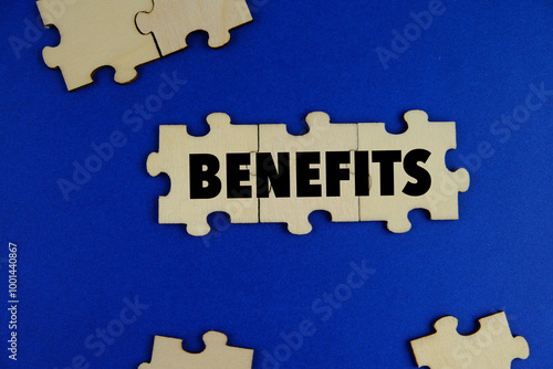 The word benefits on wooden puzzle o blue background. the concept of profit. business concept photo