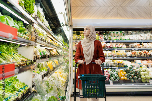 Happy mature Asian woman looking  products at grocery store. Costumer buying food at the market. Woman enjoying her time shopping at the grocery store