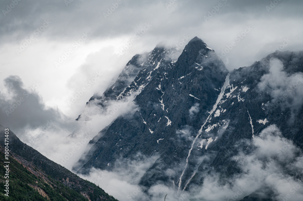 High mountains surrounded by clouds and mist High mountains surrounded by clouds and mist