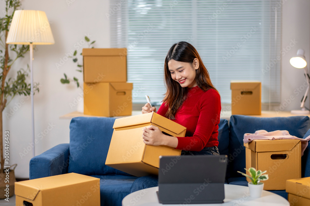 A woman is sitting on a couch with a box in front of her A woman is sitting on a couch with a box in front of her