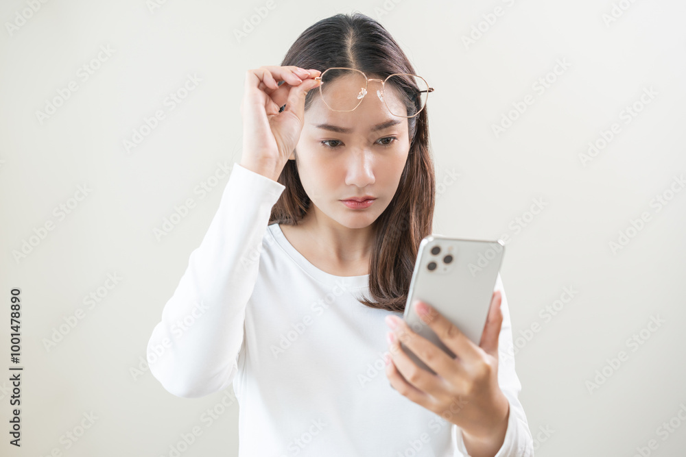 Presbyopia, Hyperopia middle aged asian woman holding eyeglasses problem with vision blurred ,trying to read text message from smart mobile phone screen, eye disease of old, eyesight farsightedness.