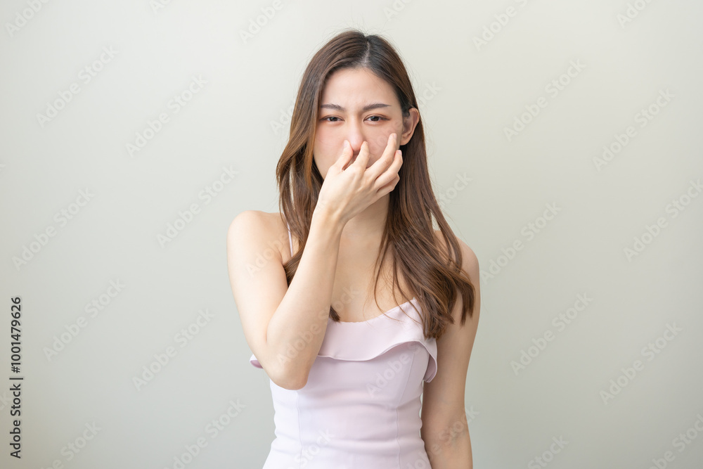 Portrait of pretty brunette hair, disgust smell bad strong asian young woman, girl hand squeezing, covering nose with fingers, expression face disgusting, dislike odor isolated on white background. Portrait of pretty brunette hair, disgust smell bad strong asian young woman, girl hand squeezing, covering nose with fingers, expression face disgusting, dislike odor isolated on white background.
