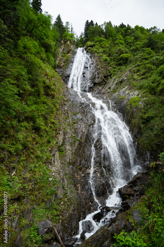 Looking up at the waterfall on the mountain cliff from a low angle