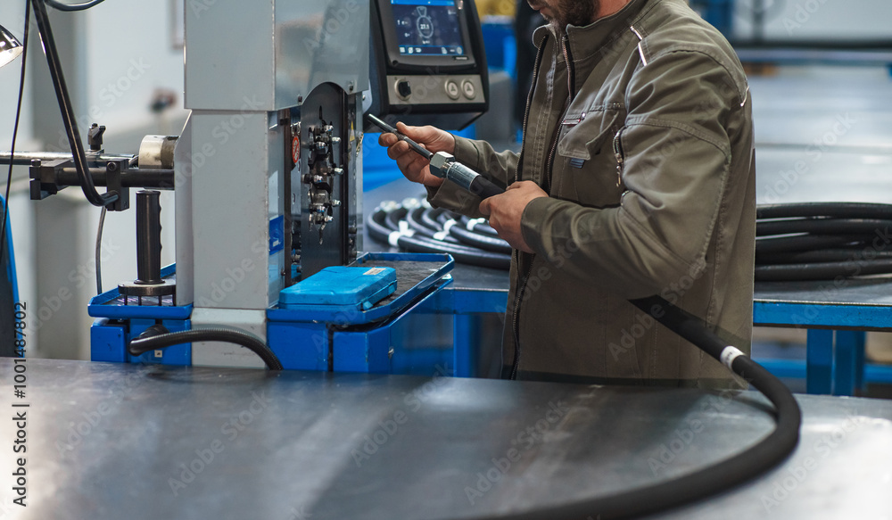 Worker assembles high pressure hose. High pressure hose production. Worker assembles high pressure hose. High pressure hose production.