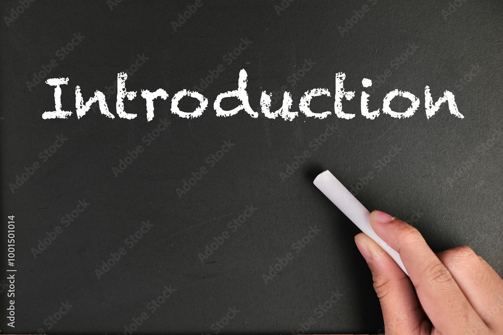 text of INTRODUCTION with hand holding chalk on black board and school tools and stationeries for back to school conceptional. text of INTRODUCTION with hand holding chalk on black board and school tools and stationeries for back to school conceptional.