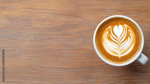 Coffee cup with latte art on wooden table, close-up view.