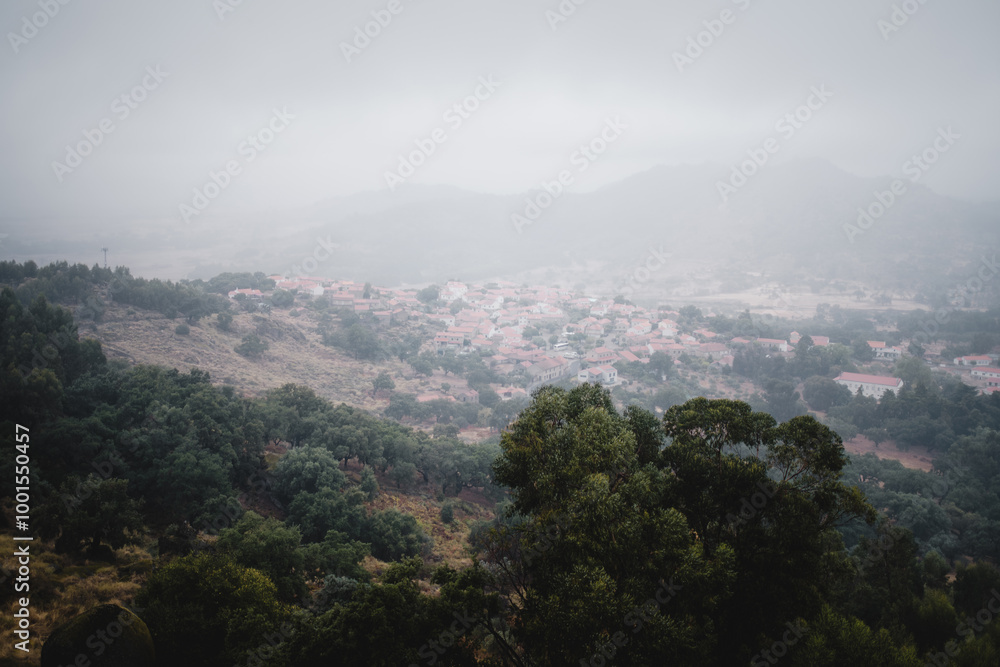 Fototapeta premium A panoramic view of the village in Monsanto, Portugal, as fog rolls down into the valley, covering the landscape in a serene and mystical blanket.