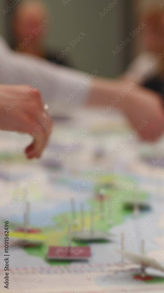 Process of playing tabletop board game on the table, fun with friends and family in room indoors, board game concept, company group of students adults play board games, roll the dice on a game map Process of playing tabletop board game on the table, fun with friends and family in room indoors, board game concept, company group of students adults play board games, roll the dice on a game map