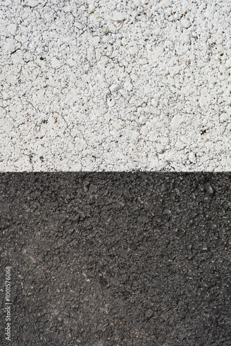 Detail of an asphalt road with half painted in white