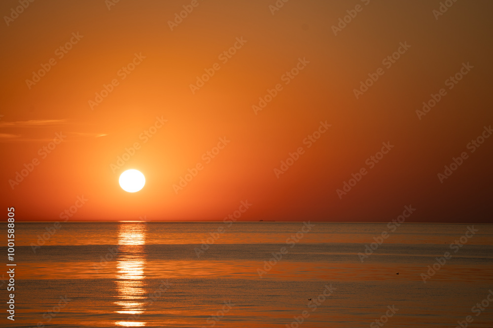 pinkish blue seawater against a pink western sky pinkish blue seawater against a pink western sky