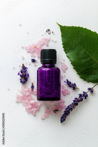 Lavender essential oil bottle surrounded by flowers and leaves on a white sur...
