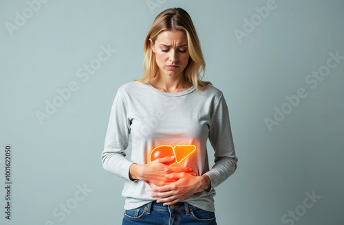 Woman with blond hair looks worried and holds her hands on her stomach. Her liver is glowing orange-yellow. Space for text. 
