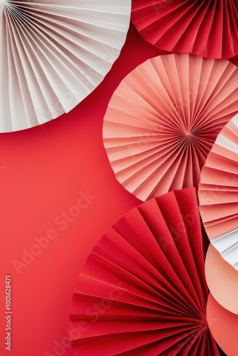 Decorative paper fans in red, black, and white arranged on a vibrant red back...