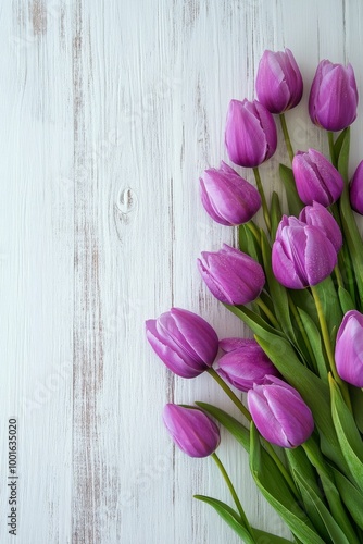 Fresh purple tulips arranged beautifully on a rustic wooden table with natura...
