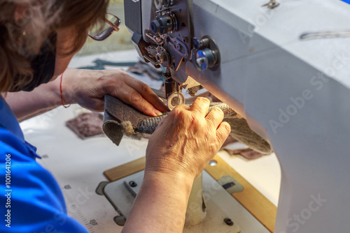 The staff of footwear factory works on special sewing machines. photo