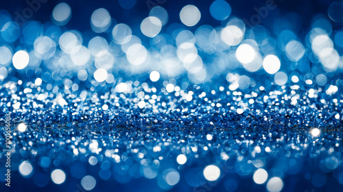 A soft-focus image featuring blue bokeh lights and glittering particles, creating a magical and dreamy visual effect.