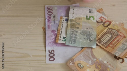 Child businessman, young entrepreneur carefully arranging and counting euros, laying out notes on table, Learning value of money, instilling financial literacy and smart money habits from young age