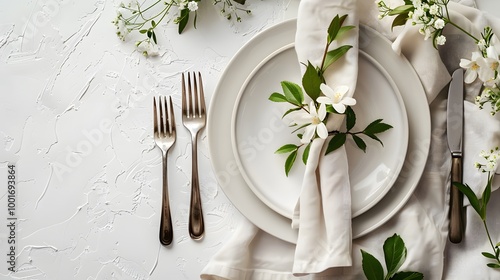 Elegant table setting with white plate, silver cutlery, and flower decor on white background. Flat lay design with copy space for wedding or event invitations, banners, or restaurant marketing.