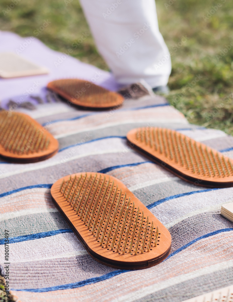 Standing on sadhu board, process of barefoot standing on nails therapy, view of legs feet on nails, yoga and sadhu practice, outdoor meditation with nailing practice, wooden nail board, summer day Standing on sadhu board, process of barefoot standing on nails therapy, view of legs feet on nails, yoga and sadhu practice, outdoor meditation with nailing practice, wooden nail board, summer day