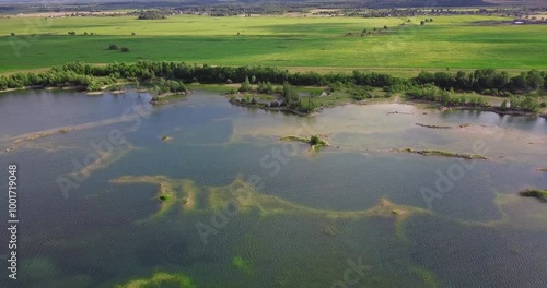 Bird's-eye view of a beautiful pond with islands in the middle of green meadows.