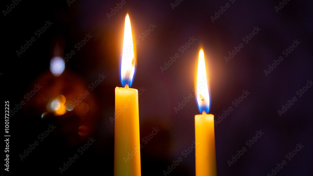 two candles with bright flames at night on a black background, Christmas celebration two candles with bright flames at night on a black background, Christmas celebration