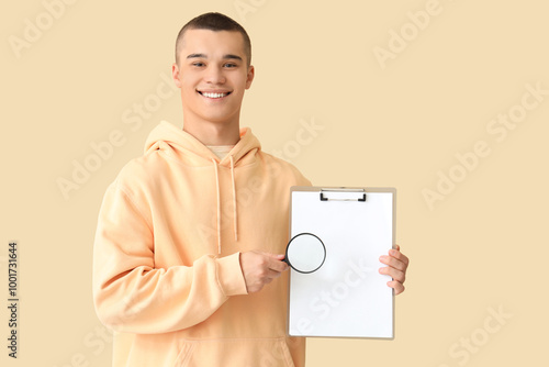 Young man with magnifier an...