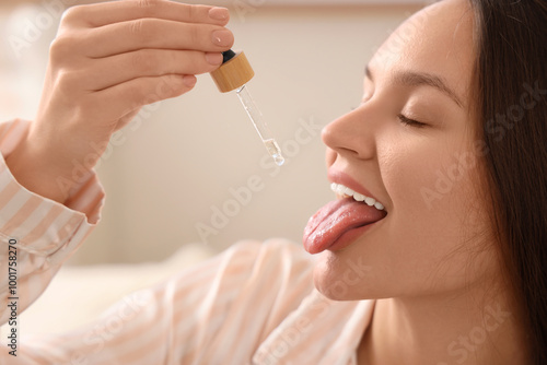 Young woman taking CBD oil ...