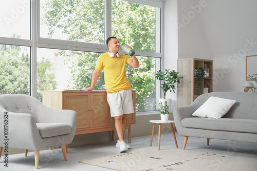 Sporty young man drinking w...