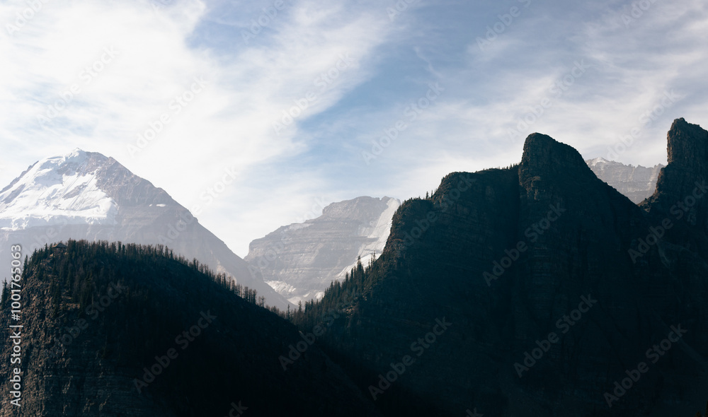 view of the silhouette of a mountain over a valley with a mountain range in the background in summer with smoke in the air view of the silhouette of a mountain over a valley with a mountain range in the background in summer with smoke in the air